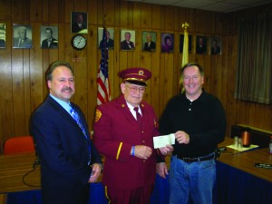 Past Chief and Senior Trustee Andrew Cody (center) of Buchanan Engine Company No. 1 presents donation check to Jerry Underwood, co-chair of the fundraising committee, while Buchanan Mayor Sean Murray looks on.