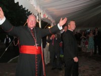 Cardinal dolan enters the John f. Kennedy Catholic high School flanked by father Mark Vaillancourt, the school’s principal.