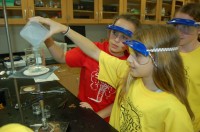 AP Physics students Jesse Bauer and Allison Kitain use a tube of flames to demonstrate the resonance of sound waves.