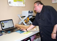 Cash for Gold's Wesley Griffin demonstrates how the value of a precious metal is determined using the nearby Niton Analyzer and a computer.