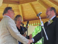 The Rev. Lynda Clements marries Alan Stahl, left, and Ossining Mayor William Hanauer at Sparta Park on Sunday.