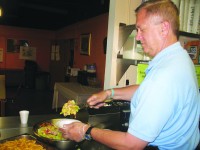 Peekskill Rotary Club member John Mattis prepares salad for clients at the Jan Peek house in Peekskill.