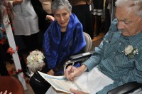 Bride Muriel Siragher watches as her groom Murray Silverman signs the wedding contract. 