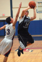 Putnam Valley’s Andre Soto fires shot over triple-team defense of Carmel’s RJ Martinez, JJ O'Connor and Dan Behnken in Tigers’ 56-55 overtime win against Rams last Monday. Photo by Ray Gallagher