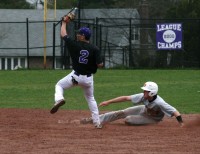 Huguenots shortstop John Valente (left) after he is sure he made the tag on Adams gestures to the umpire to show that the baseball is securely in his glove, as Adams awaits the umpire’s verdict. Adams was called safe and the Tigers went on to score four runs with two outs in the sixth inning. Photo by Albert Coqueran                                                    