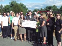 Gipson, Alvarez, Tobin hold a 0,000 check that will go to a new playground at Kent Elementary. 