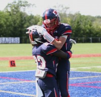 Crusaders halfback Malcolm Major (left) is enthusiastically congratulated by teammate wide receiver Andrew Geni (right) in the end zone after his 82-yard touchdown run in the first quarter. Photo by Albert Coqueran