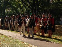 Revolutionary War soldiers stand at attention while the Pledge of Allegiance is spoken. 