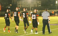 In a show of unity, the Tigers [l-r] Cameron Crabbe, Lukas Repetti, Marshon Morris and Chris Jordan clutched hands as they walked on the field for the coin toss to begin the game in New Rochelle. Photo by Albert Coqueran