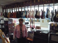 Cindy Radovich stands in front of the R&D Music; surrounded by guitars and other instruments the store has had for many years. 