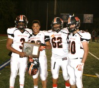 White Plains High School seniors Cameron Crabbe, Chris Jordan, Jerry Rivera and Eduardo Rios are presented the Section 1 AA Championship Plaque, after the Tigers beat North Rockland High School, 20-11, to capture the school’s first ever Section Title. Photo by Albert Coqueran