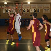 Stepinac forward Tyrin Miller (center) leaps over Ireton center David Senft (left), as they fight for a rebound in the matchup of the two powerhouse Catholic basketball conferences, at Stepinac High School, on Sunday, Dec. 22.