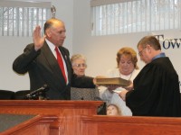 Bill Huestis stands tall as he is sworn in with plenty of family members surrounding him. 