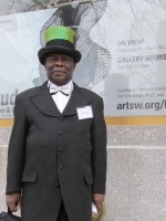 Shadows of the Mad Hatter, Carlos of Carlos Hats poses in from of ArtsWestchester wearing one of his own designs.