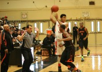 WPHS-1 | The Examiner News Tigers Jordan Tucker passes under pressure in the White Plains vs. Spring Valley Section 1 Quarterfinal game. Tucker had 19 points in the game but in the third quarter his two points was the only field goal for White Plains, which led to a 69-66 loss to Spring Valley. Photos by Albert Coqueran
