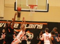 Spring Valley’s forward Jordan Duncan (left) drives on White Plains forward Justin Tapper for two of his ten second-half points. Duncan finished the game with 17 points and 10 rebounds.