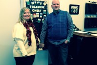 Carla and Michael stand in front of the “Quitter’s Wall” at White Plains Vapors where customers have tacked their last pack of cigarettes. 