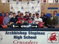 Nine student/athletes participated in National Letter of Intent Day at Stepinac High School on Tuesday, April 15. Pictured wearing caps indicating their college selection with respective coaches are: (l-r front) Eric Terminello–Naval Academy-Golf, Angelos Paradisis, Edinboro University-Wrestling, Sheldon Salmon, SUNY Brockport-Football,  Bandon Campos, Villanova University-Baseball. (Back row l-r) Liam O’Donnell, Catholic University-Lacrosse, Joseph Somereve, Castleton State-Football, Brain Harris-Merchant Marine Academy-Football and Joe Signore, St. Thomas Aquinas-Baseball. Albert Coqueran Photo