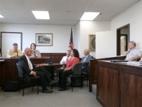 Putnam Valley Supervisor Bob Tendy (black suit, near left) and county health commissioner Dr. Allen Beals (blue suit, far right) argued over the closing of Spur Beach at a July Health Committee meeting with legislators looking on. 