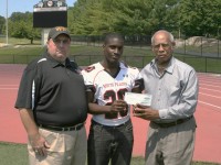 Daniel Bonner (center) a linebacker on the Tigers 2014 Section 1 Championship Team is the recipient of the 17th Annual Art Monk Scholarship Award. Bonner was presented a check for 00 and a trophy designed by Monk by Head Coach Skip Stevens (left) and Dan Woodard, who is the designated presenter of the award. Albert Coqueran Photo