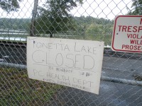 A sign at Tonetta Lake indicates the beach is closed until further notice. The county’s health department made the call after green algae was discovered.