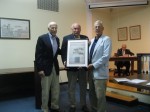 Bedford residents Herb Kaufmann, left, and Peter Milano, right, presented Mount Kisco Mayor Michael Cindrich with a copy of the July 1781 map of the French Army encampment 