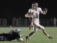 Greeley quarterback Cameron Ciero eludes John Jay's Shawn Casey during Saturday's playoff game. 