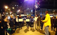 Mayo Bartlett, in the yellow jacket, addresses those gathered at Fountain Plaza in White Plains Tuesday night regarding the need for law enforcement to embrace best practices.