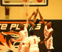 Woodlands forward Denzel Small (center) attempts to get a shot off but he is fouled by Tigers Robert Walker (right), as White Plains defenders surround Small under the basket. 