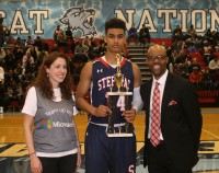 Stepinac’s Jordan Tucker (center) was presented the Most Valuable Player of the Game Award by Big Apple Basketball President Jason Curry (right) and Emily Pierslie (left), a representative of sponsor Microsoft. Tucker scored 25 points and grabbed 14 rebounds in the Crusaders, 70-65, win over Marshall. 