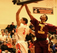 Tigers junior guard Luis Cartagena (left) slips under Knights Justin Alleyne with his trademark backward layup; but it was not enough as Mt. Vernon beat White Plains, 58-45.