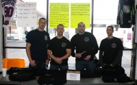 [L-r] White Plains Firefighters Cole Martin, Billy Simons, Rich Servello and Roberto Fortuna man the station selling “Battle of the Bravest” insignia T-shirts and raffle tickets for prizes, as they raise money for the Ronald McDonald House of the Greater Hudson Valley. 