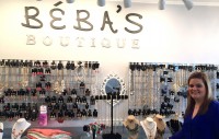 Matina shows off some of the jewelry displayed on one wall of Beba’s Boutique in White Plains.