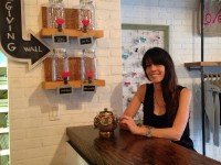 Trish Kallman, owner of hip-kid, stands by the Giving Wall in her children’s clothing store in Chappaqua.