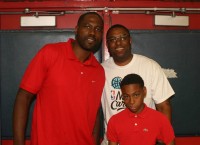 Artie McGriff, Jr. (front right) manages a nervous smile as he joins his uncle NBA star Elton Brand (left) and his father Artie McGriff, Sr. who is Brand’s brother, during a photo opportunity at the 2015 Elton Brand Youth Day at Peekskill H.S. on Saturday, Aug. 8. 