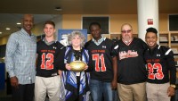 Art Monk (left), a graduate of WPHS (’76) and a three-time NFL Super Bowl Champion presented a Wilson Gold Football to his alma mater’s football program, as part of the NFL’s Super Bowl High School Honor Roll initiative. The Gold Football was accepted on behalf of WPHS by [l-r] quarterback Tommy Avery, Principal Ellen Doherty, tackle Elijah Ojo, Head Coach Skip Stevens and running back J.J. Hernandez. Albert Coqueran Photos