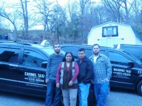 : Ruth Pardo Ayala-Quezada stands with some of dedicated staff in front of a Carmel Taxi vehicle and Mahopac Taxi vehicle. DAVID PROPPER PHOTO 