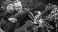 Soldiers founder and singer-songwriter Darden Smith embraces a veteran at a previous retreat. 