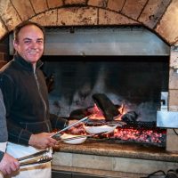 Dubrovnik Restaurant founder Jerry Tomic at his wood burning brick oven. 