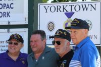 : Councilman Tom Diana poses with veterans in front of new Purple Heart Town sign at corner of Triangle in Yorktown. 