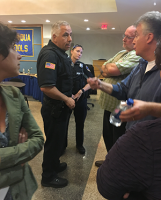 New Castle police officers talk to several angered parents during a recess at Tuesday’s Chappaqua Board of Education meeting, which became tense when the public demanded its turn to speak.