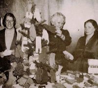 Eleanor Clark of the Woman’s Club shows mittens to Mrs. Reisner of the Children’s Day Care Center and Mrs. Carson from St. Bart’s Church. Source: Woman’s Club archives.