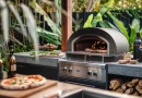 Outdoor kitchen with a multi-fuel pizza oven, showcasing wood, gas, and charcoal fuel options for versatile backyard pizza making.
