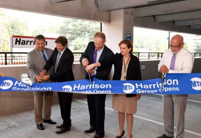 Five people cutting a ribbon at Harrison train station