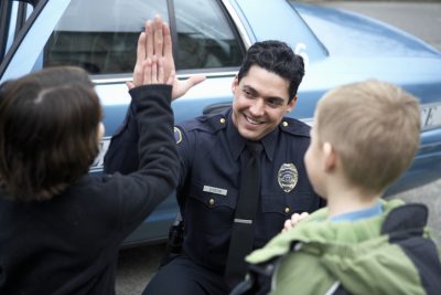 Police officer high-fiving a young child