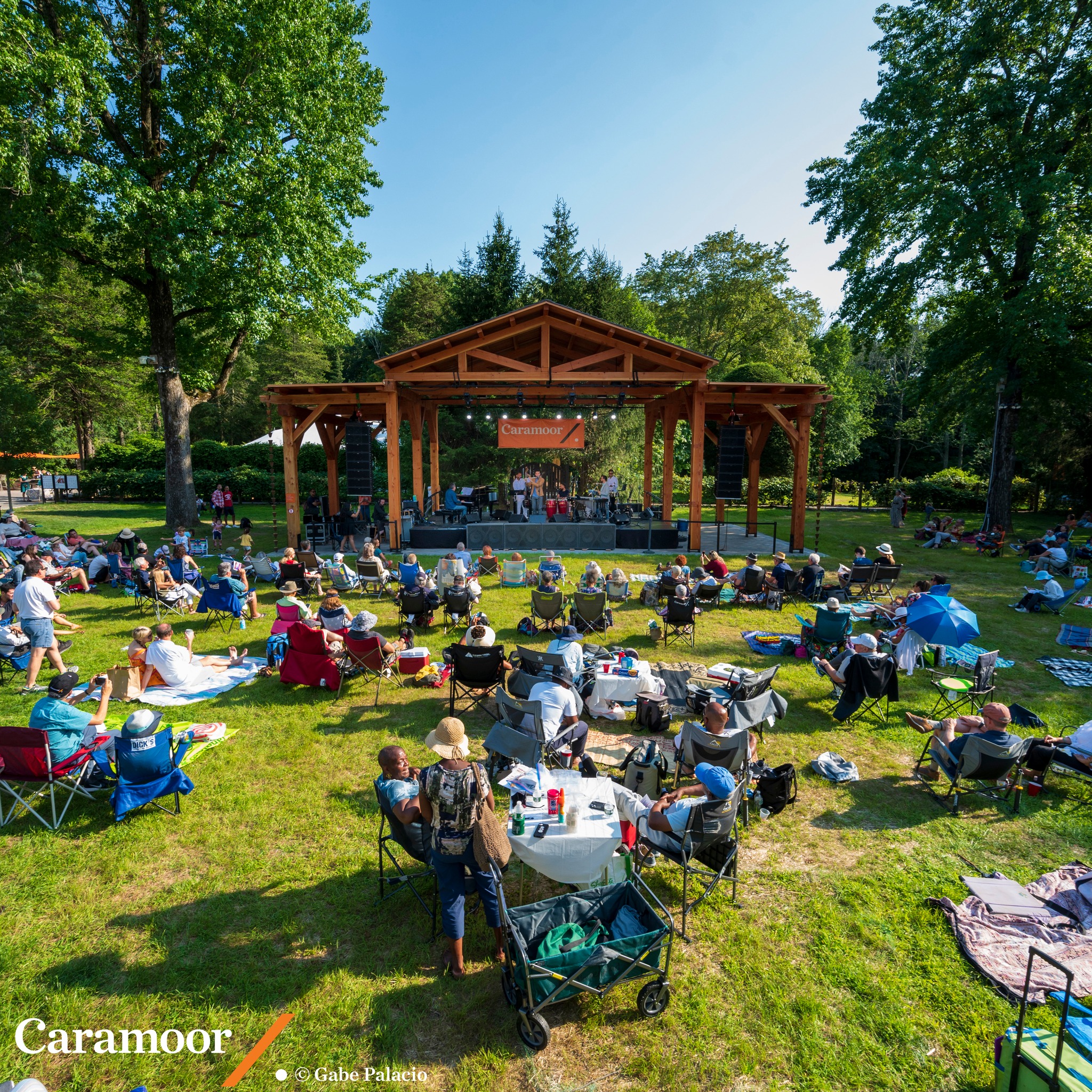 May be an image of one or more people, outdoors, tree and text that says 'Caramoor'